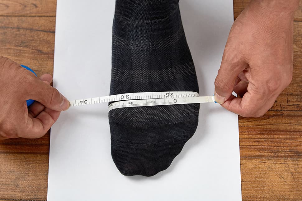 親指の付け根と小指の付け根のいちばん出っ張った部分を結んだ足の甲周り寸法を測ります